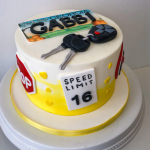 New driver birthday cake with keys, license and signs