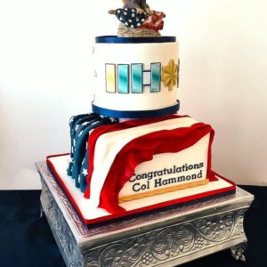 Tiered retirement cake with draped flag and ranks.