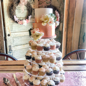 Two tiered ombre rose gold cake with cupcakes