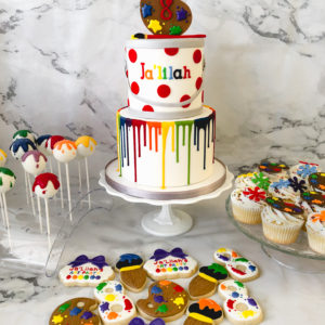 A painting drip cake with matching cake pops, cupcakes and cookies.
