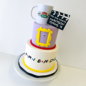 A Friends themed cake with a real Central Perk mug on top