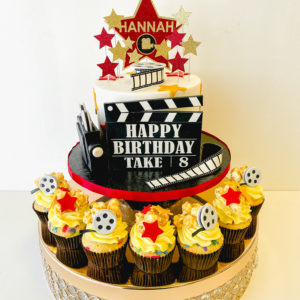 Movie themed cake with glitter star topper and movie themed cupcakes