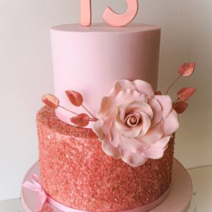 A pink cake with rose gold cake sparkle on the bottom