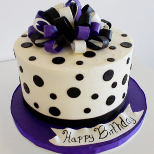 Fondant black polka dot cake with a fondant bow on top