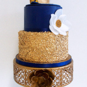 Two tiered fondant cake with wafer paper flower, edible gold sequins and gold edible shoe on top