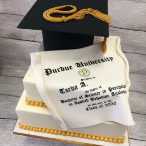 Simple two tiered graduation cake with diploma and cap