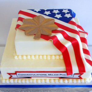Two tiered buttercream cake with fondant flag and Air Force major symbol on top