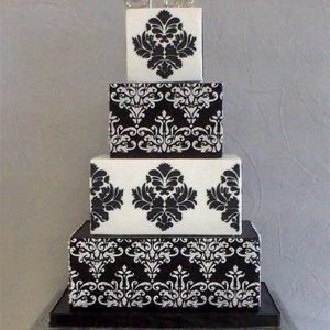 Alternating black and white tiers with a royal icing damask pattern