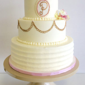 Buttercream cake with royal icing drop strings painted gold