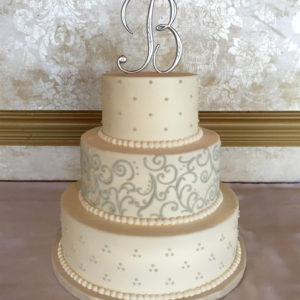 Buttercream cake with grey dots and piped swirls.