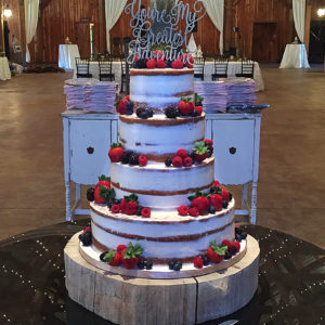 Multi tier semi-naked cake covered in fresh berries.