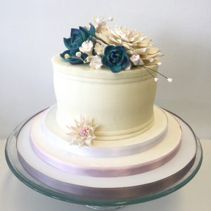 Single tiered buttercream cake with sugar succulents and blossoms.