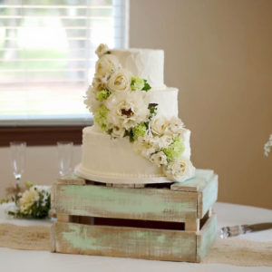 Rustic buttercream cake with real flowers arranged by the bride's florist.